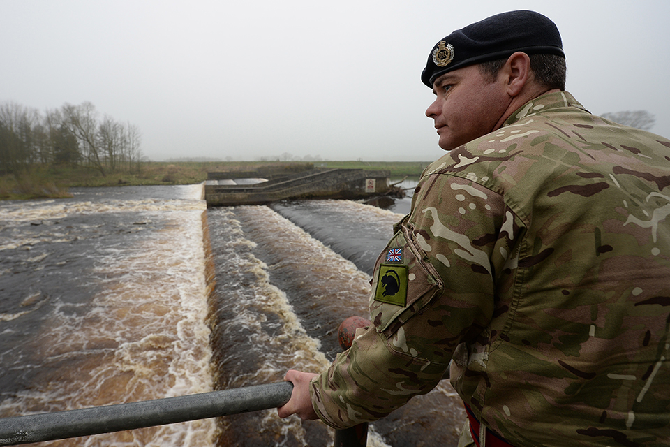 A sapper from 21 Engineer Regiment inspects flood defences 