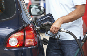 Photo of a person putting fuel in a car at a petrol station