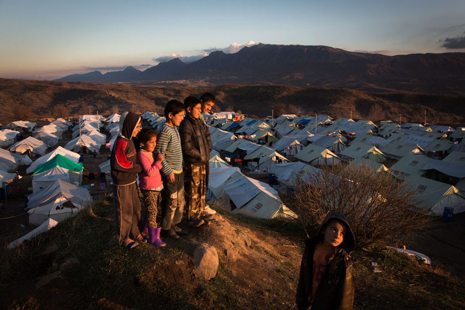 Children look out over an informal camp for families displaced from their homes by ISIL in northern Iraq. The camp, which was recently home to around 1000 families has been supplied with tents by UK aid. Picture: Andrew McConnell/Panos for DFID