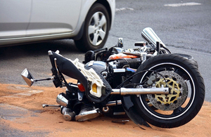 Image of a damaged motorcycle by a car