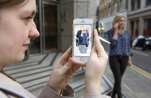 Image of Jenny Lewis, founder of Snap Fashion taking a picture of a passer by with a mobile phone.