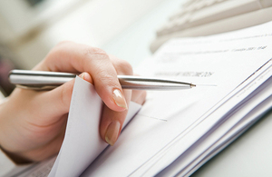 A woman signing some papers.