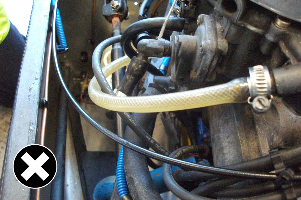 Not allowed: the petrol pipe is rubbing against the HT lead and is not clipped into place.
