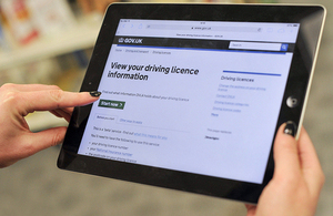 A person't hands holding a tablet looking at the View Driving Licence service start page.