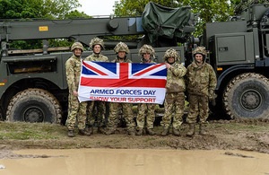 Soldiers next to Armed Forces Day flag