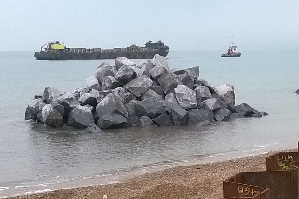 A photo showing rocks placed on the sand that may be covered by high tides