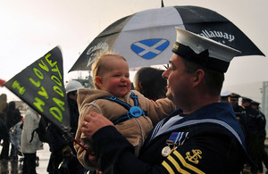 A member of HMS Bangor's ship's company is welcomed home by his baby son at HM Naval Base Clyde, Faslane
