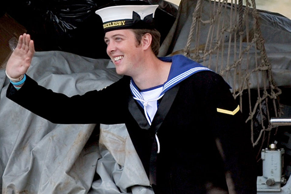 A sailor onboard HMS Brocklesby waves to his family waiting on the jetty