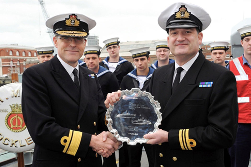 Rear Admiral Duncan Potts presents the Mine Warfare Trophy to Lieutenant Commander James Buck, Commanding Officer of HMS Brocklesby