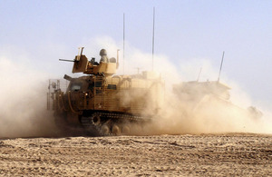 Corporal Tristan Cordery checks the rear cab as he pulls out in the new Warthog vehicle