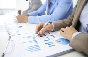 Someone holding a pen while studying a chart in a document