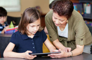 teacher and young girl using a tablet