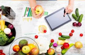 a picture of a computer tablet with food and a person's hands