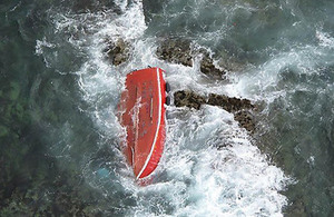 Upturned fishing vessel on rocks