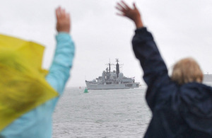 Family members wave from the shore as HMS Edinburgh departs from Portsmouth Harbour