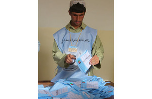 An Afghan election worker examines some of the ballots cast in Lashkar Gah during the recent parliamentary elections