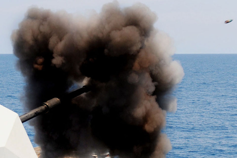 A 4.5-inch gun is fired from a Royal Navy warship, with the shell captured in flight