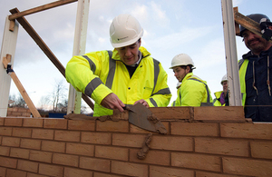 Chancellor helping to construct a wall