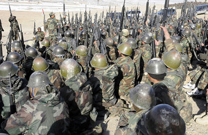 Afghan National Army trainees raise their weapons in acknowledgment of their Afghan trainer during a basic training lesson at the Kabul Military Training Centre