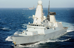 HMS Daring, with USS Carl Vinson in the background, en route to Qatar for the Doha International Maritime Defence Exhibition and Conference