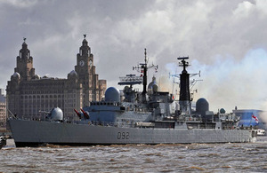HMS Liverpool leaves Liverpool for the final time, firing a gun salute as she passes the Royal Liver Building
