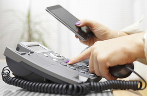 Person holding mobile and landline