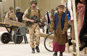 A soldier passes a 'local' in the realistic market place of the mock Afghan village at the Stanford Training Area (stock image)