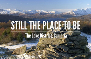 'Still the place to be. The Lake District, Cumbria' text on a winter view of hills and a lake.