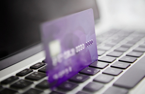 Purple credit card resting on laptop keyboard