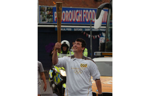 Royal Marine Lance Corporal Cassidy Little carries the Olympic Flame through Peterborough in Cambridgeshire