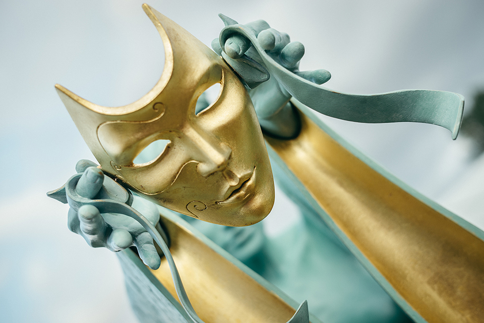 Sculpture of a person holding a mask