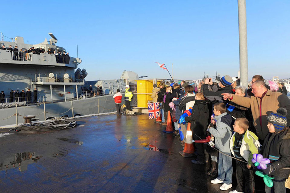 Family and friends wait at the jetty whilst HMS Montrose comes alongside