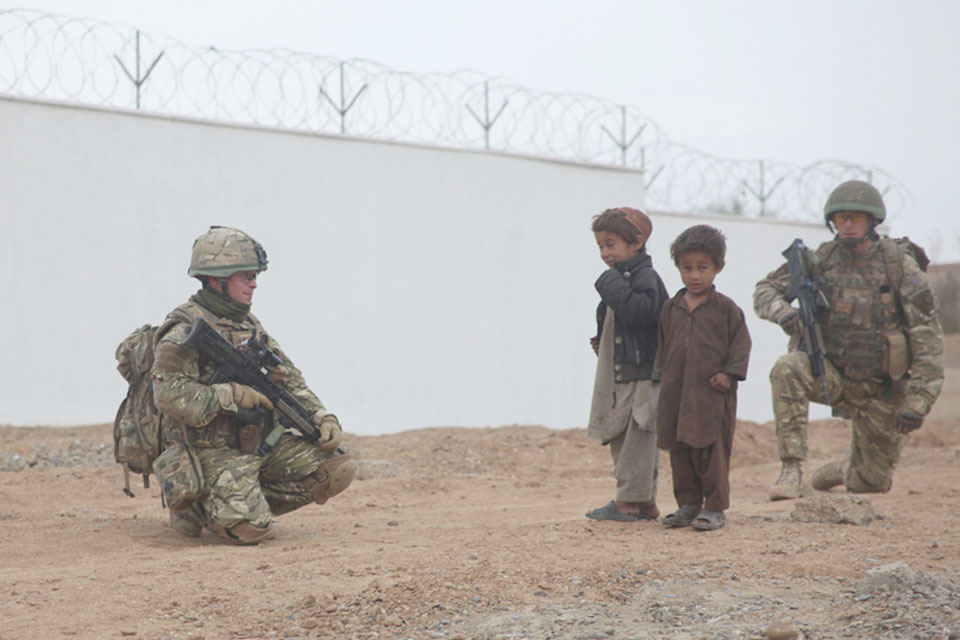 Members of the Irish Guards meet local children outside the school 