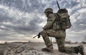 A soldier observes from a compound roof
