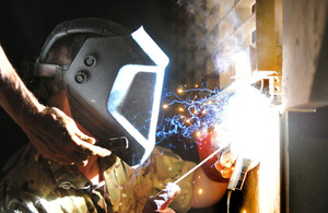 An engineer from 45 Commando's Light Aid Detachment makes repairs to a British armoured vehicle