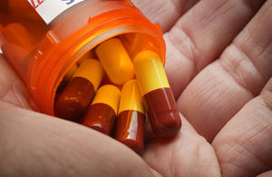 Antibiotics being poured from a pill bottle into a hand.