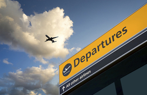 Departures sign and plane in the sky