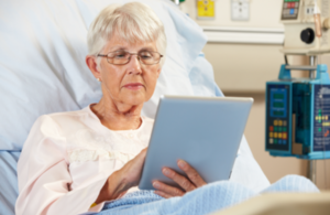 Patient in hospital bed using an iPad