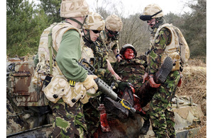 Royal Navy sailors prepare to transfer a 'casualty', role-played by a member of charity Amputees in Action, to a helicopter extraction site during pre-deployment training at Longmoor Camp in Hampshire, UK (stock image)