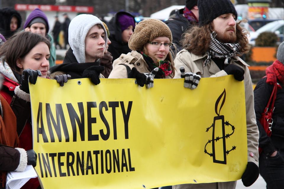 Amnesty International banner and supporters.