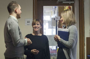 image: three people talking in a meeting