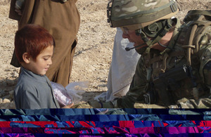 Lieutenant Ben Brading, A Company, 1st Battalion The Yorkshire Regiment, gives an Afghan child a gift for Eid