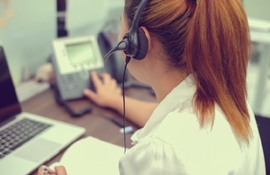 girl with headset on dialling telephone in an office