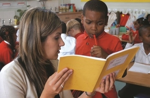 Primary school child reading with a teacher