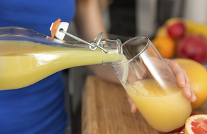 Orange juice being poured out of a jug.