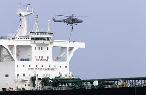 A Lynx helicopter hovers over a tanker