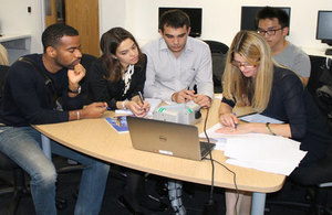 Students working around a laptop.