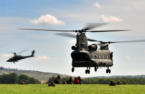 A CH-47 Chinook and a AH-64 Apache lift off after landing a team of Royal Marines during a training exercise on Salisbury Plain