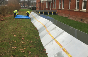 Military personnel taking part in an exercise to put up temporary flood barriers