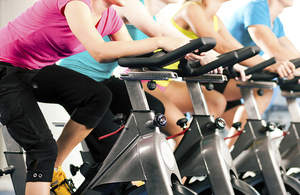 Gym goers on gym bicycles.